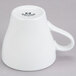 A close-up of a Tuxton Tuxton Porcelain White Cappuccino Mug with a white handle.