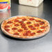 An American Metalcraft Super Perforated Hard Coat Anodized Aluminum pizza pan with a pepperoni pizza on it.