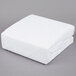 A white folded JT Eaton bed bug mattress cover on a gray background.