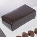 A brown candy box on a white surface filled with chocolates.