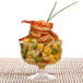 A Fineline Flairware clear plastic dessert cup filled with shrimp and fruit.