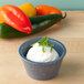A close up of a white HS Inc. blueberry ramekin containing cream cheese with green onions.