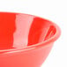 A close up of a red Thunder Group melamine salad bowl.
