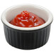 A black and white Tuxton fluted ramekin filled with red sauce.