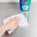 A hand using Clorox Disinfectant Wipes to clean a school kitchen countertop.