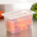 A translucent plastic container lid on a container full of peppers.