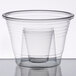 A clear plastic cup with a small glass inside.