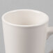 A close-up of a white Tuxton Alpine china mug with a handle.