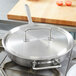 A Vollrath stainless steel fry pan on a stove.