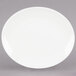 A Tuxton Venice oval coupe china platter in eggshell white on a white background.