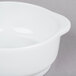 An Arcoroc white porcelain soup bowl with a handle.