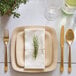 A Bambu disposable square bamboo plate with a place setting and a rosemary plant on a table.