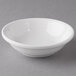 A Reserve by Libbey white porcelain fruit bowl on a gray surface.