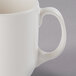 A close up of a Libbey ivory porcelain studio mug with a handle.