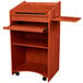 An Oklahoma Sound wooden floor lectern in a wild cherry finish with a shelf and drawer.