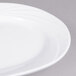 A close up of a CAC Garden State bone white porcelain platter with a wavy design.