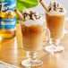 Two glasses of coffee with whipped cream and chocolate with brown liquid flavored with Torani Sugar-Free Hazelnut Syrup.