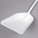 A white plastic Carlisle Sparta ice shovel with a handle.