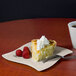 A piece of pie with whipped cream and raspberries on a Fineline Wavetrends plastic square plate.