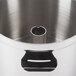 A stainless steel bowl with a metal cylinder on a white background.