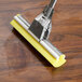 A Carlisle Flo-Pac sponge mop refill with a yellow sponge on a wooden surface.