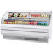 A Turbo Air white low profile horizontal air curtain display case with food and drinks.