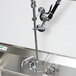 A close-up of an Equip by T&S wall mounted pre-rinse faucet with an add-on faucet.