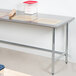 An Advance Tabco stainless steel work table with dough and a rolling pin on it.