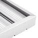 A stainless steel hood filter with ridged baffles on a metal surface.