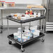 A black Metro utility cart with two shelves holding containers of food.