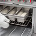 A person wearing a white glove putting bread in a Chicago Metallic aluminized steel loaf pan.