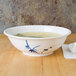 A Blue Bamboo melamine bowl filled with soup on a table.
