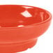 A close-up of a red bowl with a white interior and red rim.