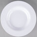 A close-up of a Carlisle white melamine bowl with a white rim.