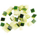 A pile of diced zucchini on a white surface.