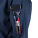 The pocket on a Mercer Culinary Millennia women's navy long sleeve cook jacket holding a phone and pens.