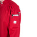 A person wearing a red Mercer Culinary chef jacket with a pocket on the back.