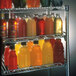 A Metro qwikSLOT wire shelf with bottles of different drinks.