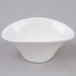 An Arcoroc deep oval porcelain bowl with a small rim on a gray surface.