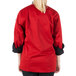 A woman wearing a red Mercer Culinary cook jacket.