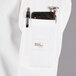 A white Mercer Culinary Millennia women's chef coat with a pocket and pen.