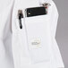 A white Mercer Culinary Millennia women's chef jacket with a pocket holding a phone and pen.
