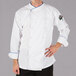 A man wearing a Mercer Culinary chef's coat with royal blue piping.