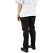 The legs of a person wearing Mercer Culinary Renaissance black chef trousers and a white shirt.