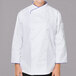 A woman wearing a Mercer Culinary white chef jacket with royal blue piping.