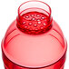 A red plastic shaker container with a lid on top and a hole.