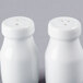 Two white ceramic bottle salt and pepper shakers.