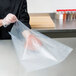 A person using an ARY VacMaster chamber vacuum packaging bag to package meat.
