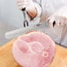 A person using a Victorinox carving knife to slice ham.