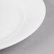 A close up of a white Reserve by Libbey International bone china side plate with a silver rim.